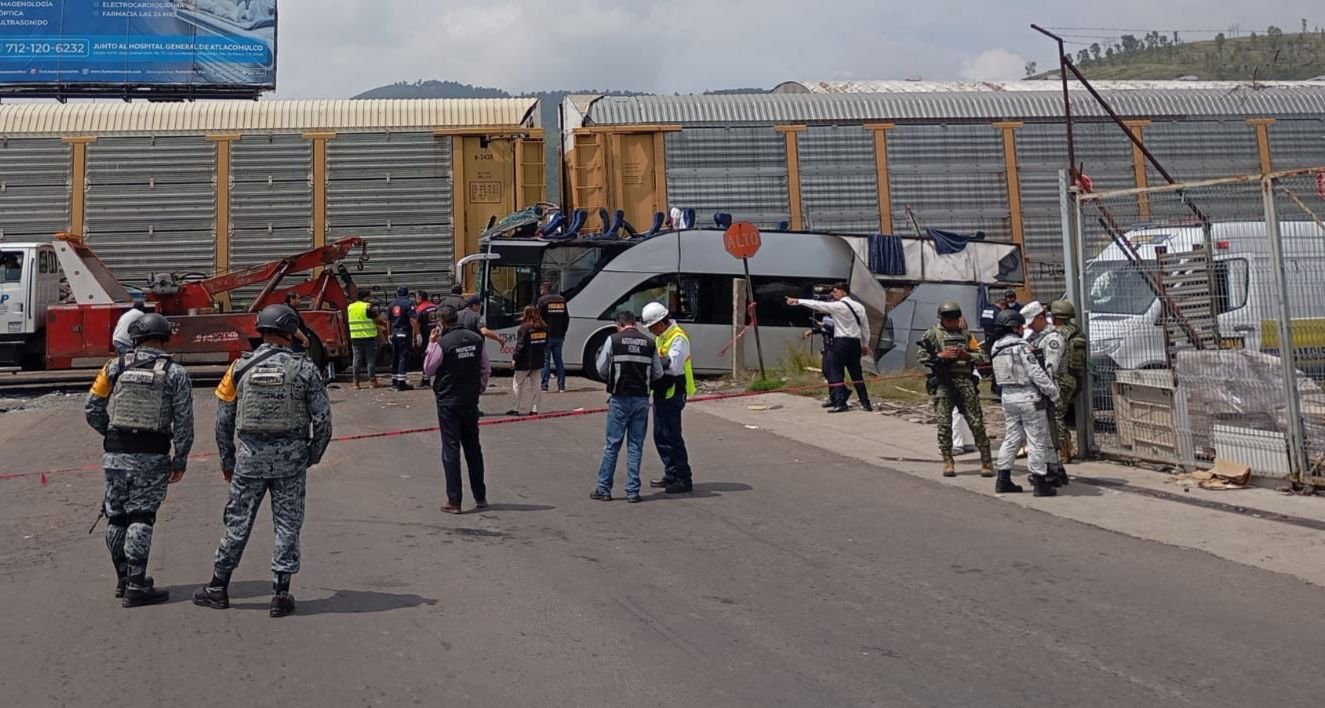 Mantienen labores tras choque de tren y autobús en Atlacomulco